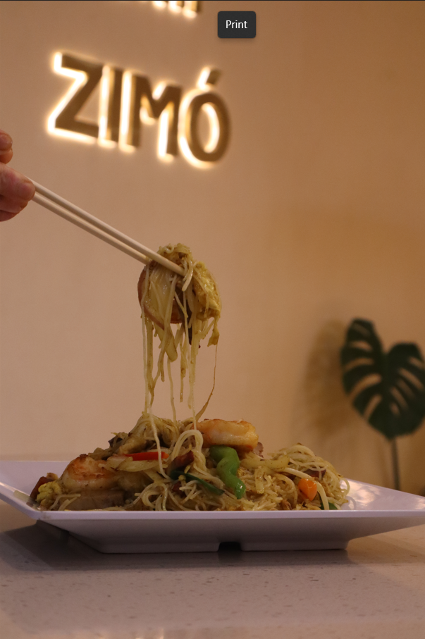 Singapore noodles lifted with chopsticks at Zimo